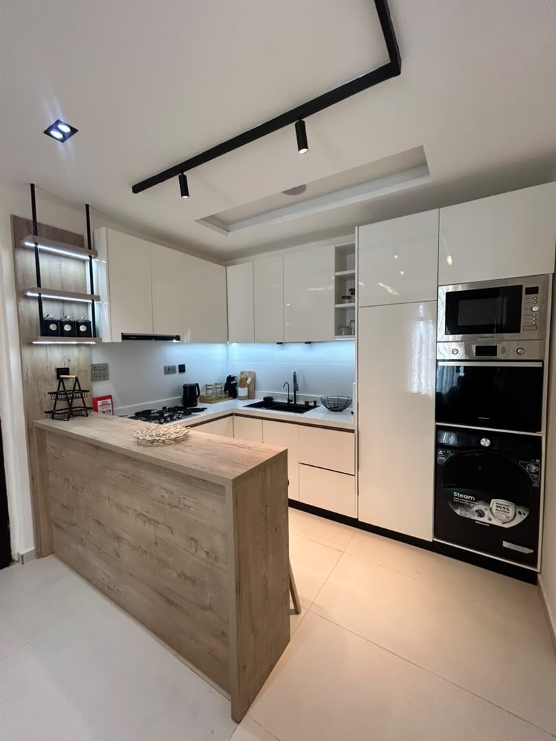 Norden kitchen: gloss-white units, a timber breakfast bar and built-in appliances