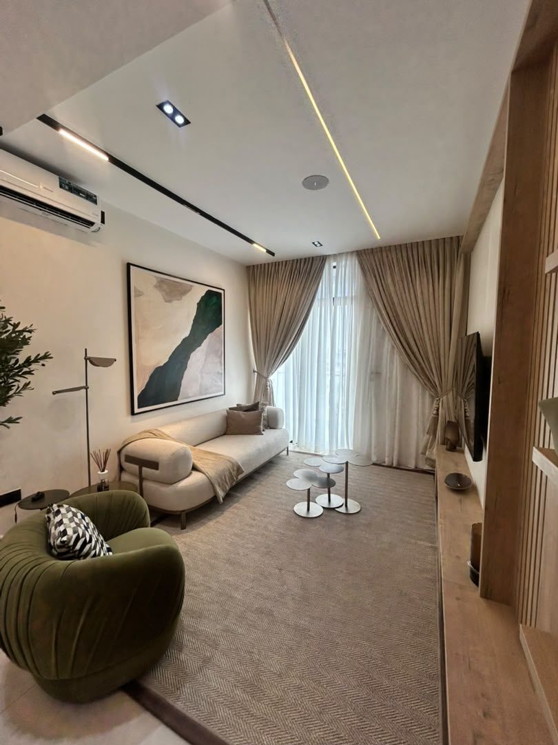 Norden living room with a cream sofa, floor-to-ceiling curtains and linear ceiling lights