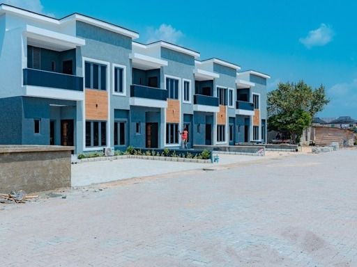 Terra Gardens: a finished row of grey and white terrace duplexes behind an interlocking paved frontage